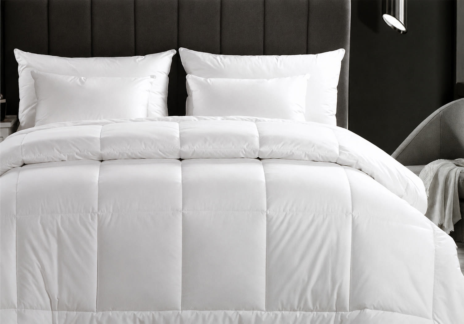 Crisp white bedding and pillows styled in a hotel room