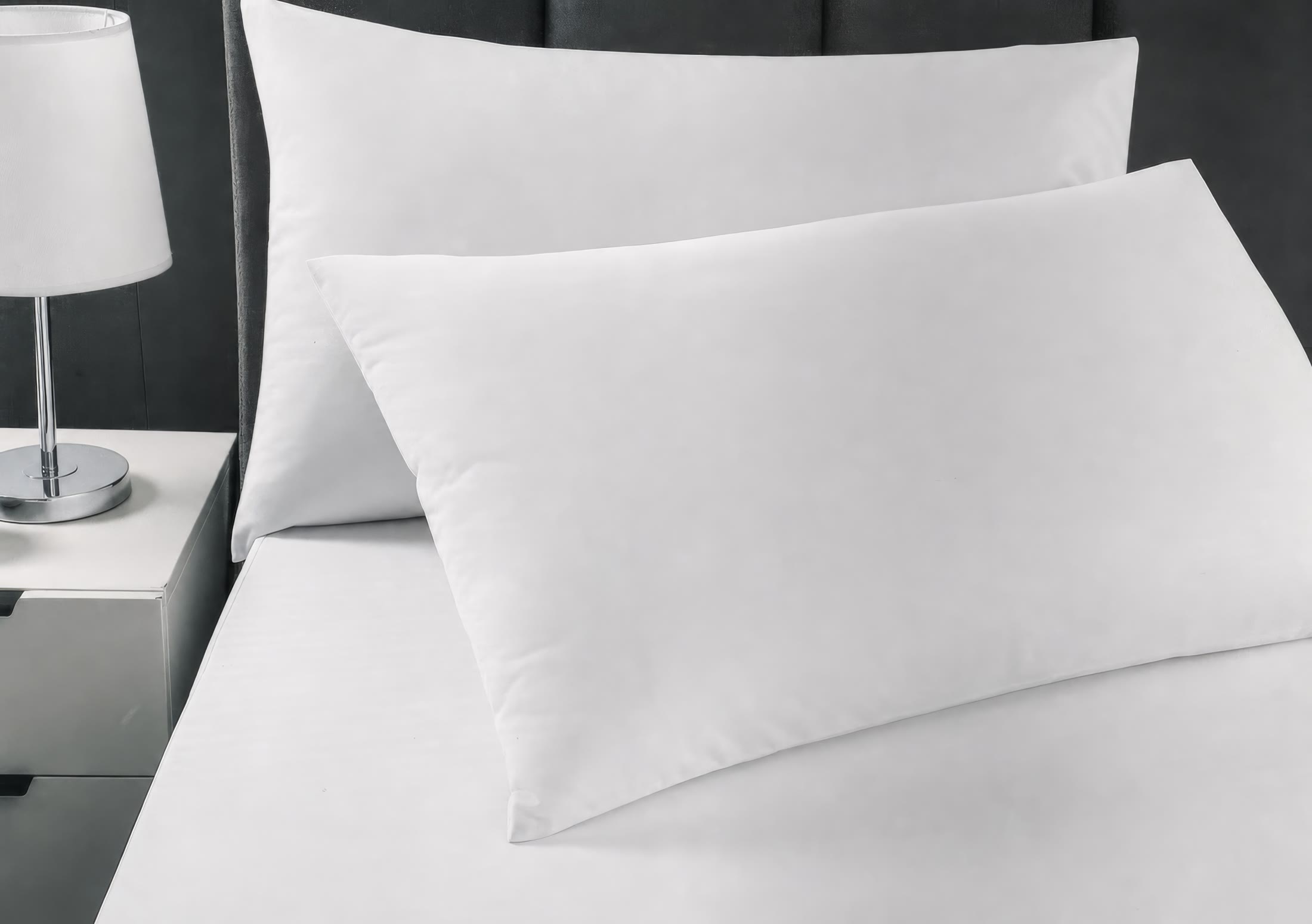 White pillow protectors and covers styled on a bed